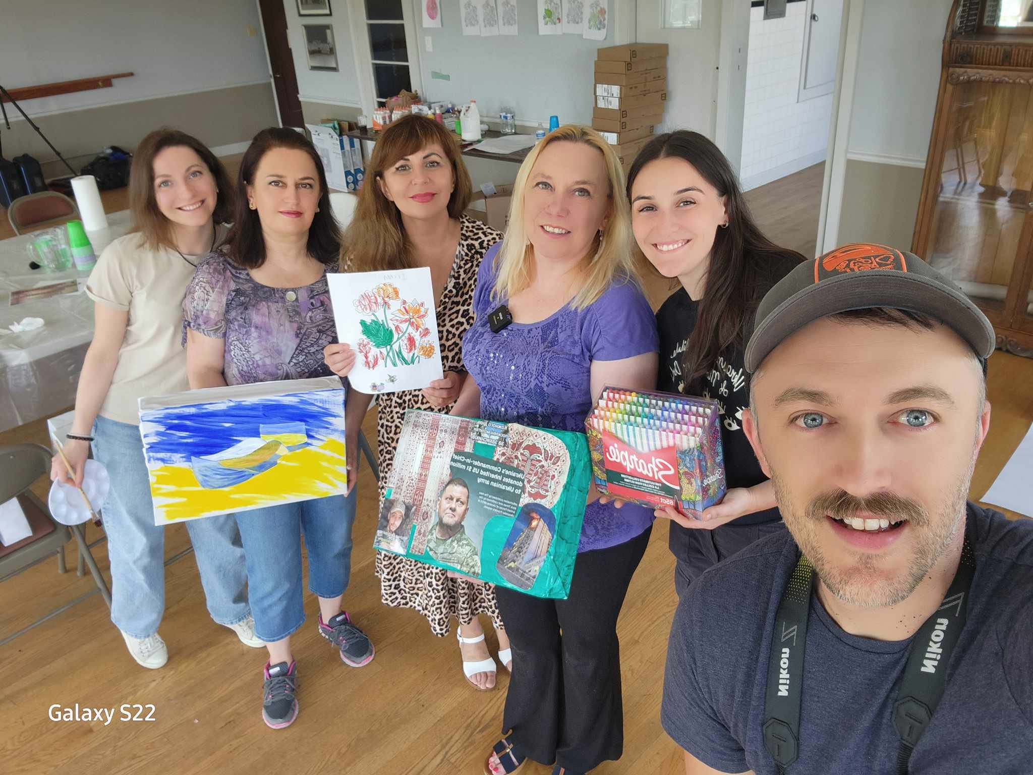 67cf41f37cd67_Radius2 (3d2d0a6d-499f-4a7e-a95a-820147c128ab) A group of people holding up their paintings.